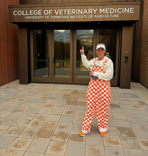 Emily King wearing the Power T cap, orange and white checkerboard overalls outside UTCVM.