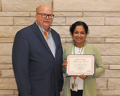 Dr. David Anderson (Left) presents Dr. Sree Rajeev, professor of microbiology, the UTCVM Boehringer Ingelheim Faculty Research Mentoring Award at the 2024 Research Day awards ceremony. The Boehringer Ingelheim Faculty Research Mentoring Award is awarded annually to a faculty member who excels in teaching, training, and sharing their knowledge with students pursuing advanced degrees in research at UTCVM.