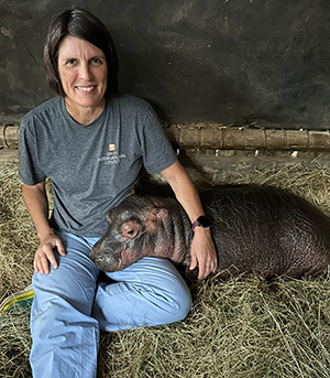 Dr. Souza with a baby hippo during a trip to South Africa.