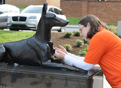 Kate Stanford (CVM ’22) examines the dog tags attached to the collar of Kurt, who was the first military working dog killed in action in Guam.
