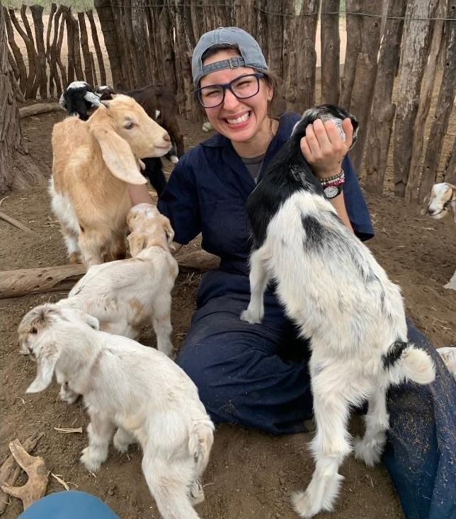 Miriam Raquel Espino Gonzalez, sitting with four goats.
