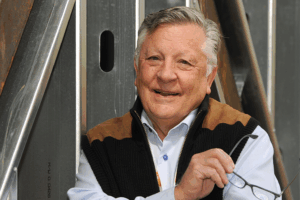 Dr. Robert DeNova posing in front of a fence.