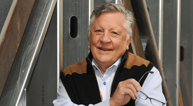 Dr. Robert DeNova posing in front of a fence.